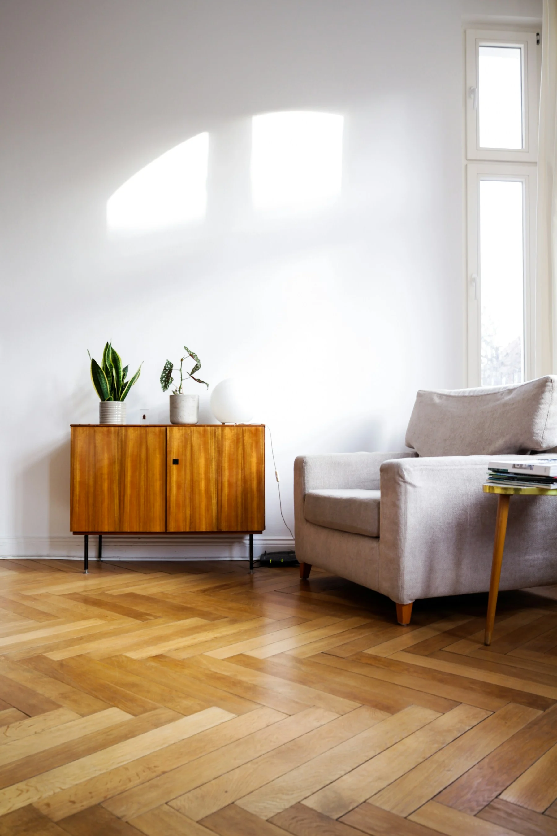 Natural wood flooring, considered furniture and sunlight in a residential interior
